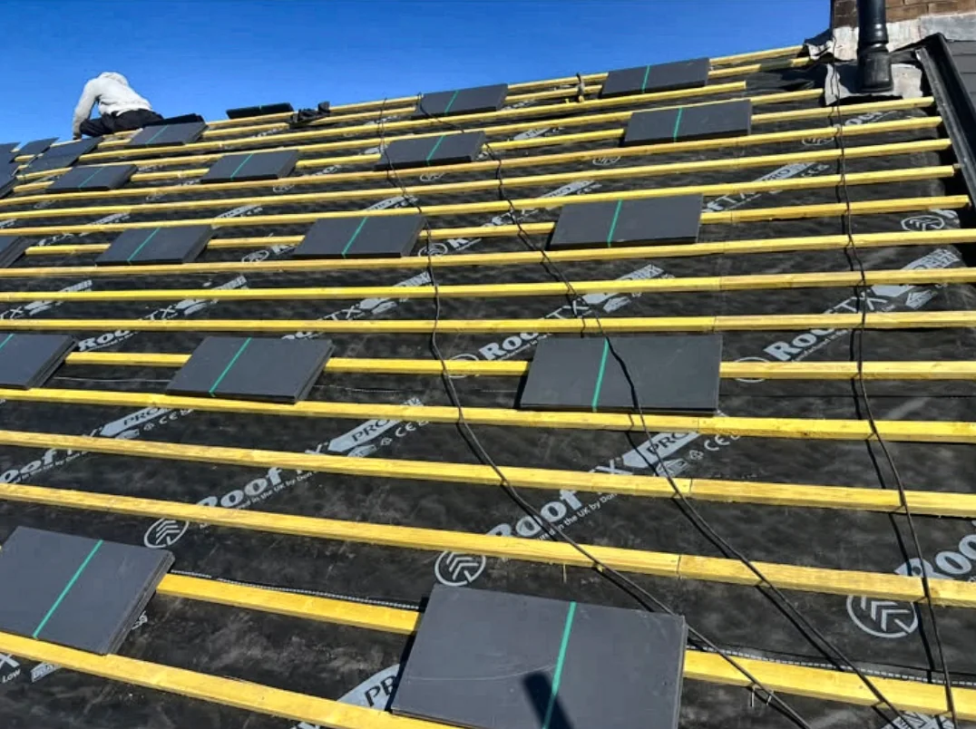 New breathable roofing membrane and treated battens being installed with slates ready to fit